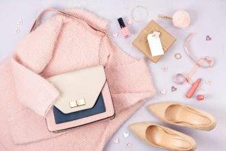 Flat lay of woman clothing and accessories in pastel colors