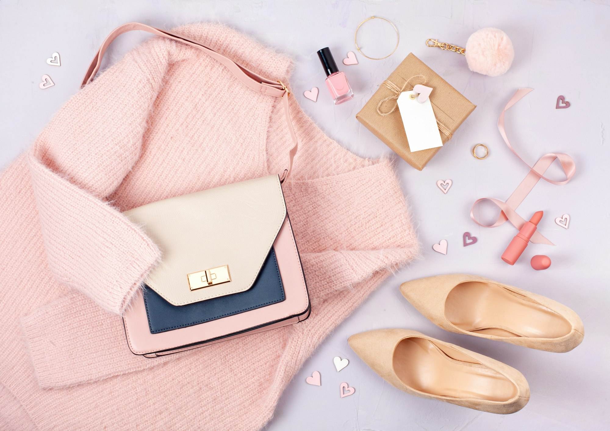 Flat lay of woman clothing and accessories in pastel colors