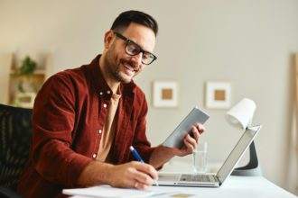 Young business man working at home with digital tablet and papers on desk